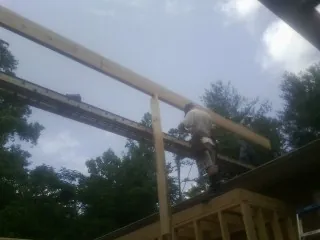 Carpenter setting a ridge beam over a new addition frame — Ice Dam Removal by Roofing Brothers in Dorset