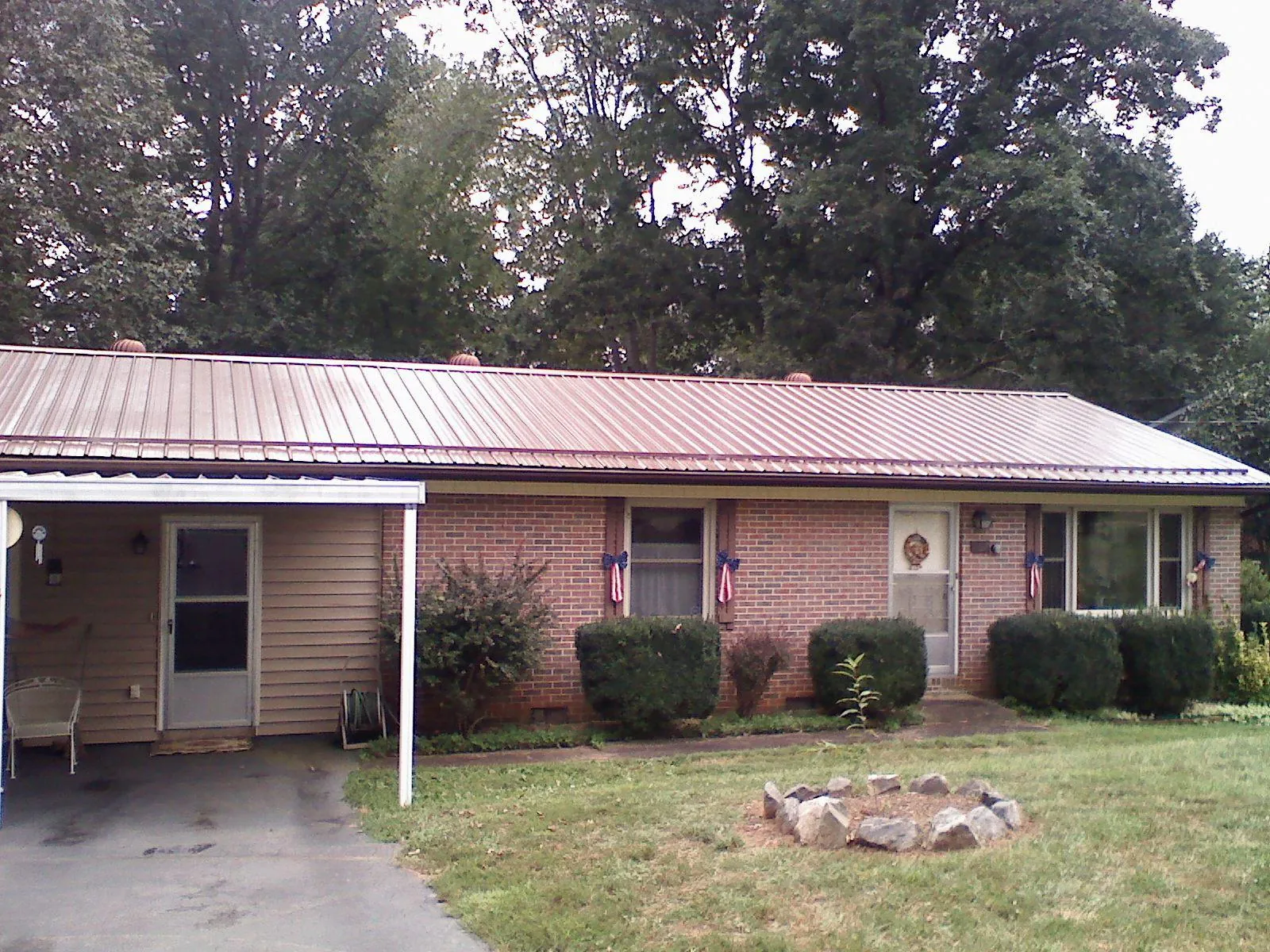 Bronze metal roof and carport on a brick ranch home — Roof Repair work by our crew in Dorset